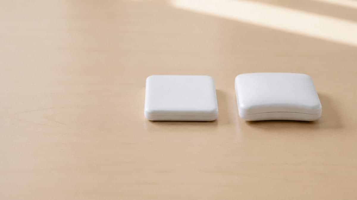 机の上に並べた2つの白いモバイルバッテリー。右のものは中央がふくらんで、置いたときにわずかに傾いている