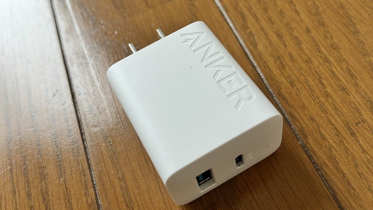 フローリングの上に置かれた白い2口の充電器。コンセントの端子が出ている